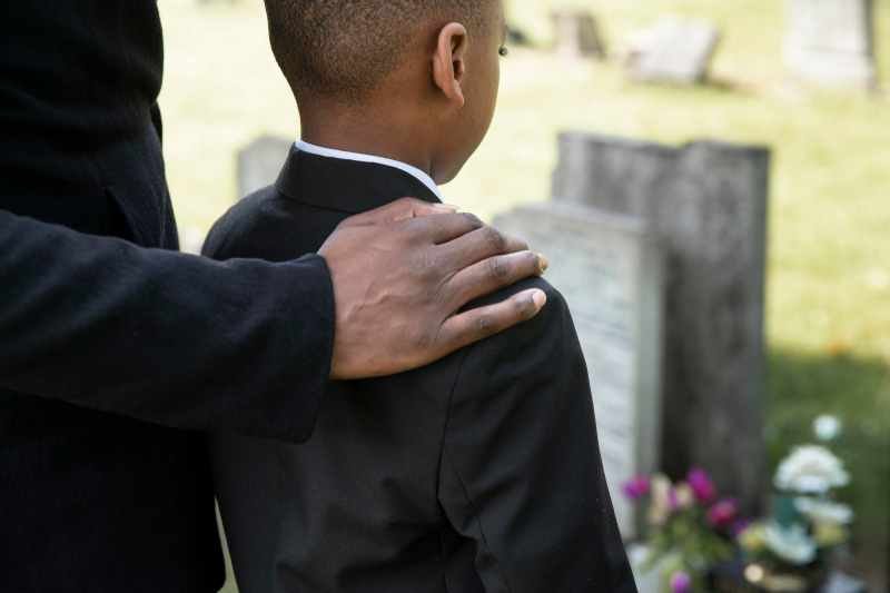 child visiting the grave of loved one